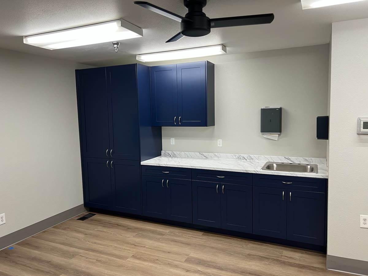 Blue commercial kitchenette cabinetry with sink and worktop
