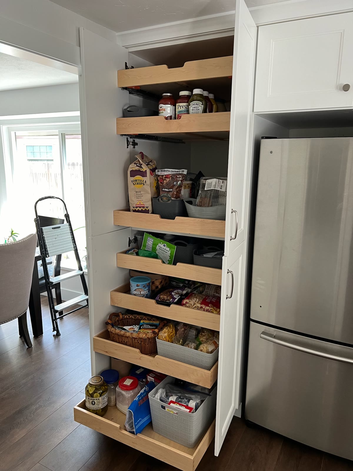 Tall custom kitchen pantry cabinet with full-extension wood pullout shelves for food storage
