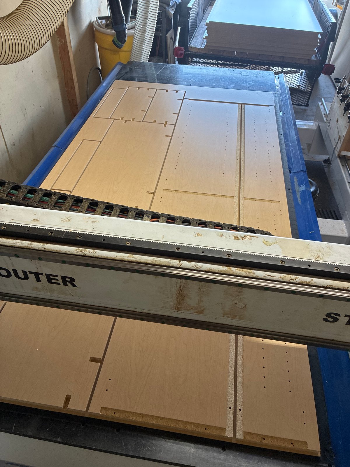 Cabinet components nested on the CNC bed before edge processing